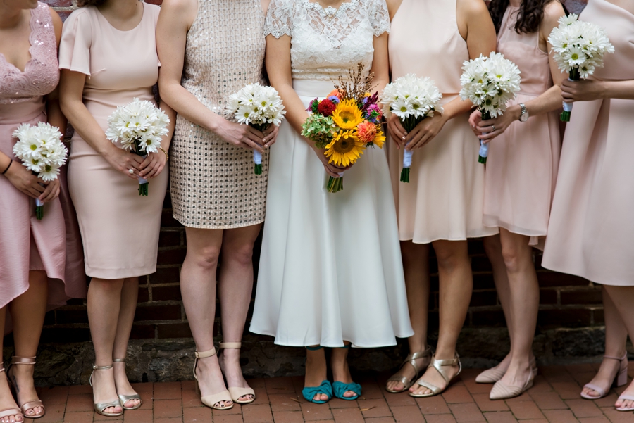 A close up of the bride and her bridesmaids shoes and flowers.